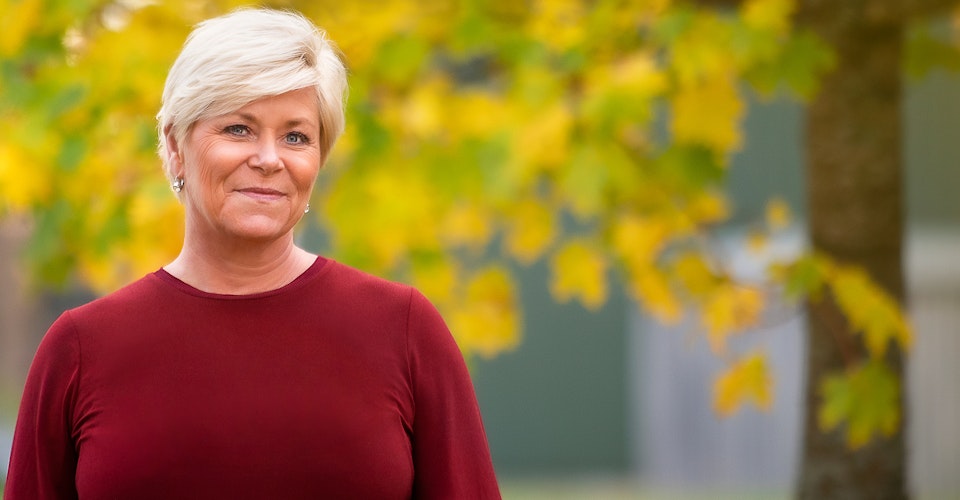 Partilederens påske Siv Jensen smilende foran trær i høstfarger. Portrett. Foto.