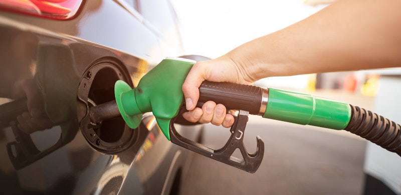 Person som fyller drivstoff på bil. Foto.