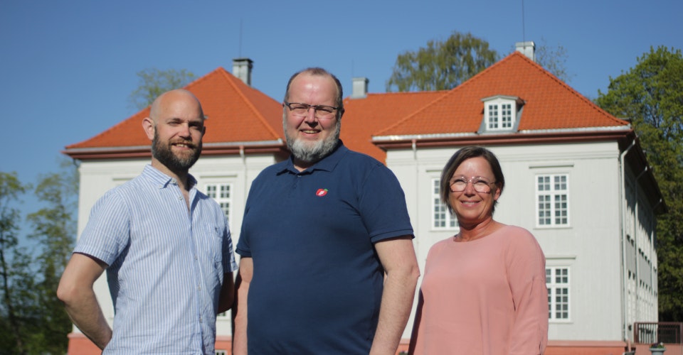 Toppkandidatene Thomas Jacobsson, Øyvind Blakset og Karin Hansen står sammen, med Eidsvollbygningen i bakgrunnen.